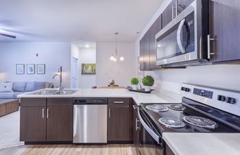 A modern kitchen with stainless steel appliances and wooden cabinets.
